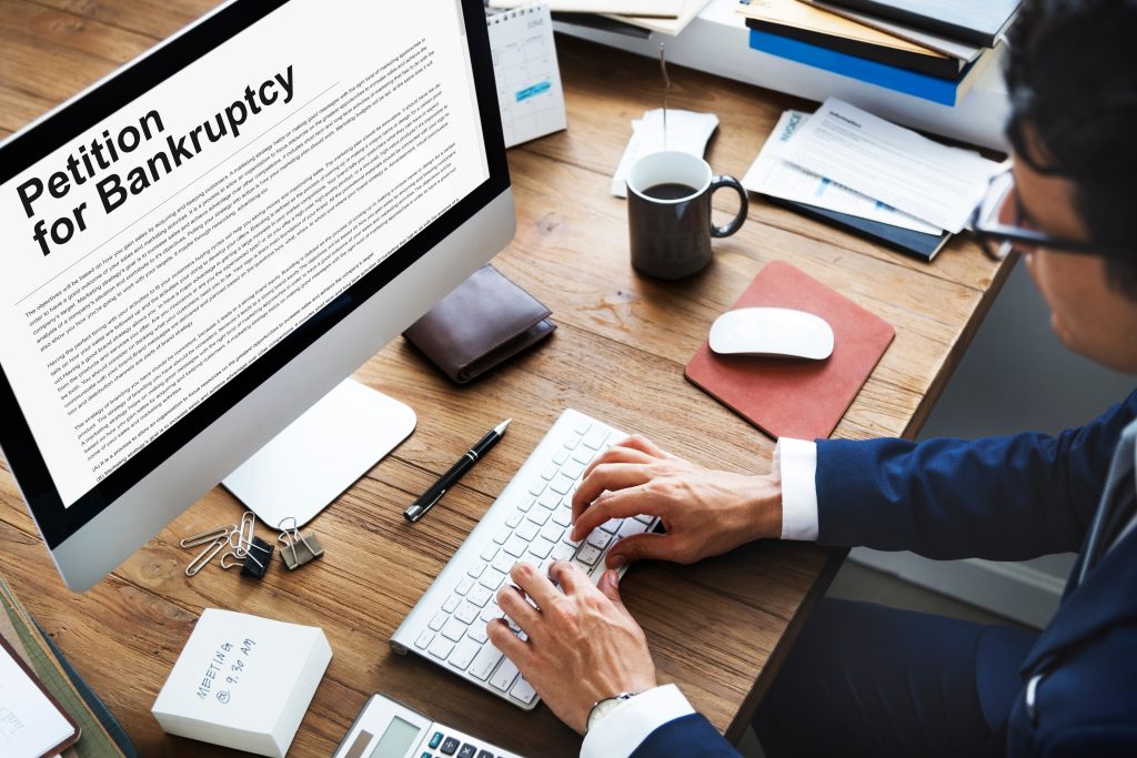 Professional reviewing legal bankruptcy documents on a desktop computer